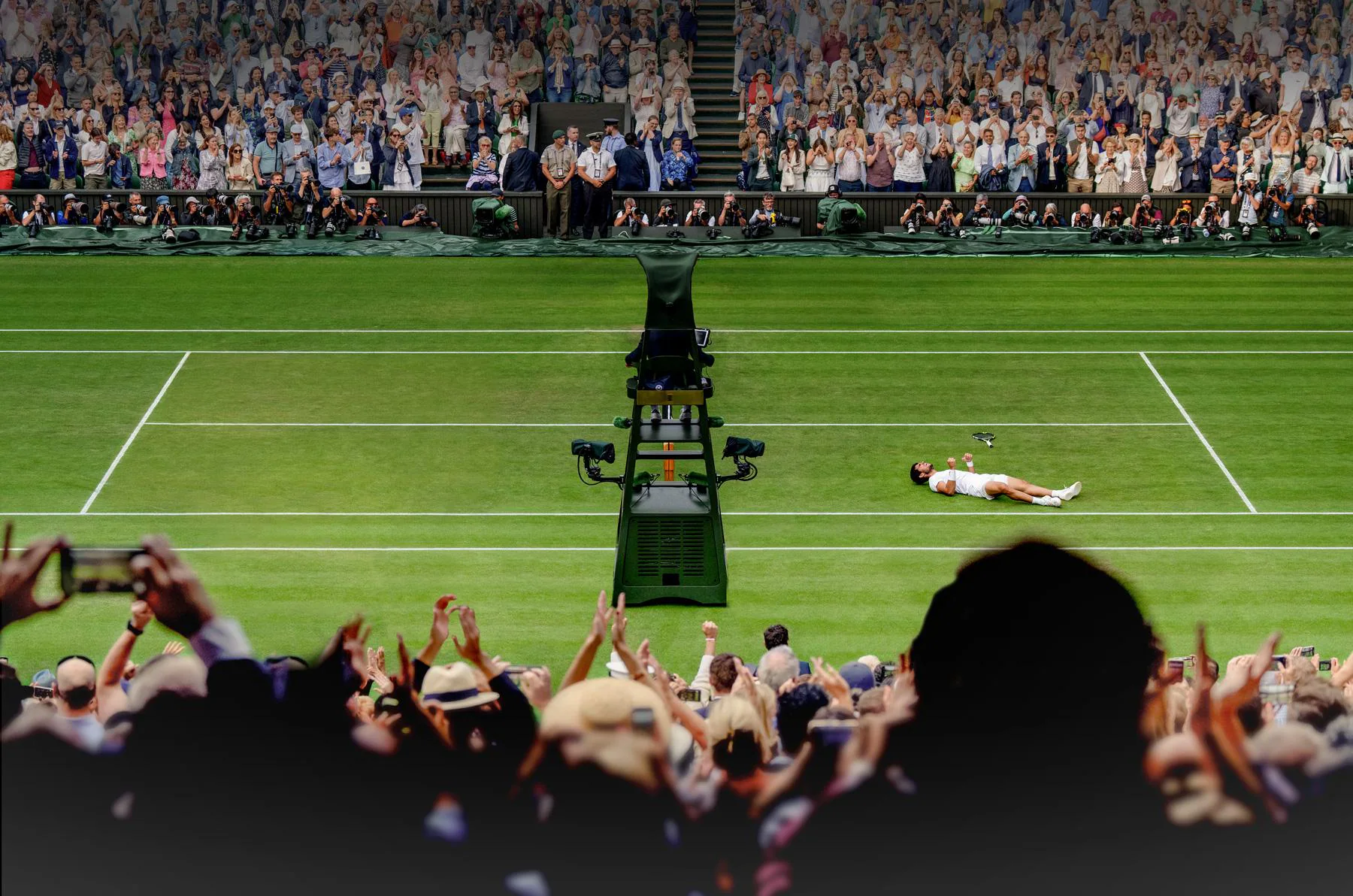 Carlos Alcaraz laying down on the Centre Court at the All England Lawn Tennis and Croquet Club in the Wimbledon Championships for tennis