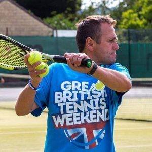 Rich Little, a LTA Level 4 Accredited Tennis Coach at Bath Tennis, hitting tennis balls during a tennis coaching lesson on the astroturf tennis courts at Bath Tennis